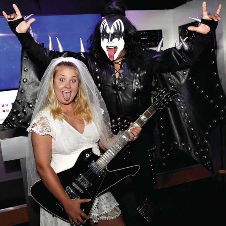 Bride holding guitar with Kiss Ministry at Rock N Roll Wedding Chapel.  