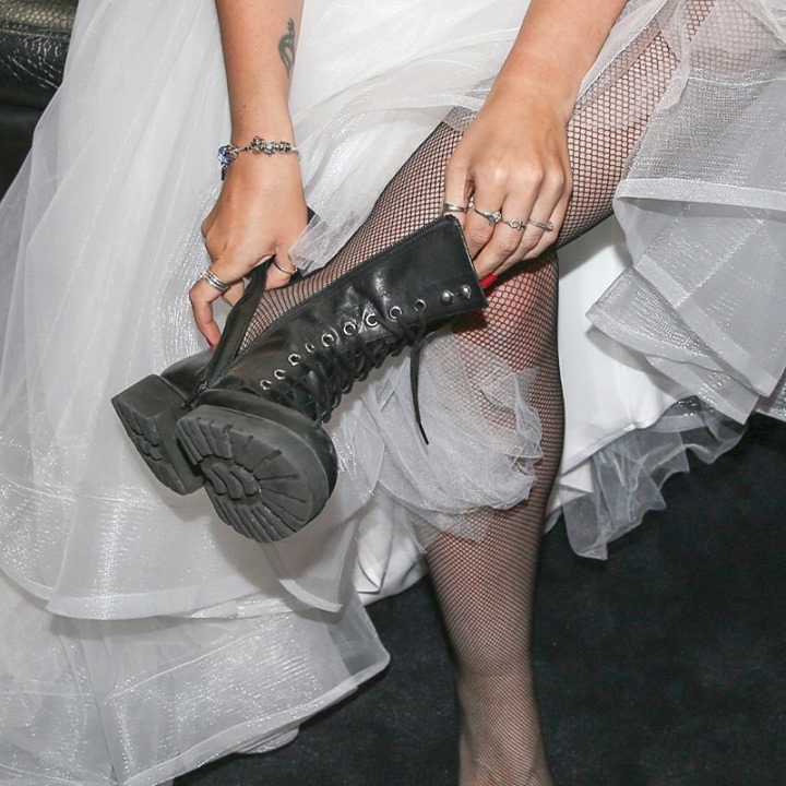 Bride putting on black boots at Rock N Roll Wedding Chapel. 
