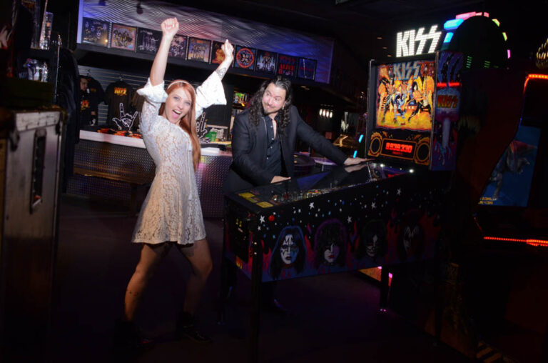 Groom and bride playing kiss pin ball machine at Rock N Roll Wedding Chapel.