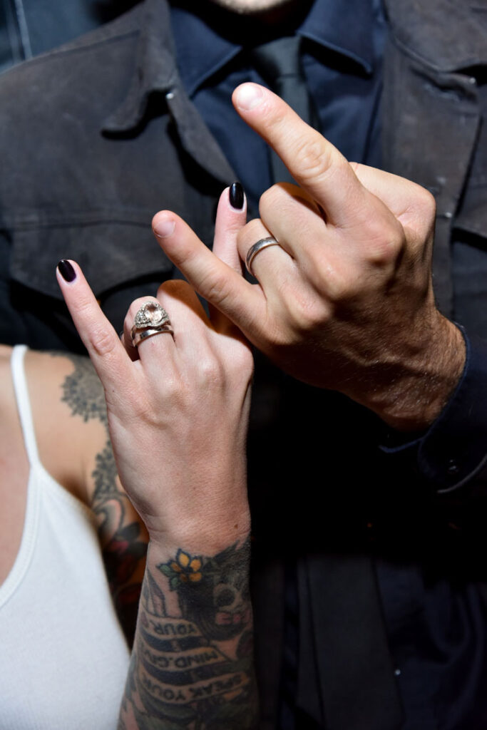 Bride at groom with their wedding rings doing a rock sign with their figures. Simple ceremony package at Rock N Roll Wedding Chapel. 